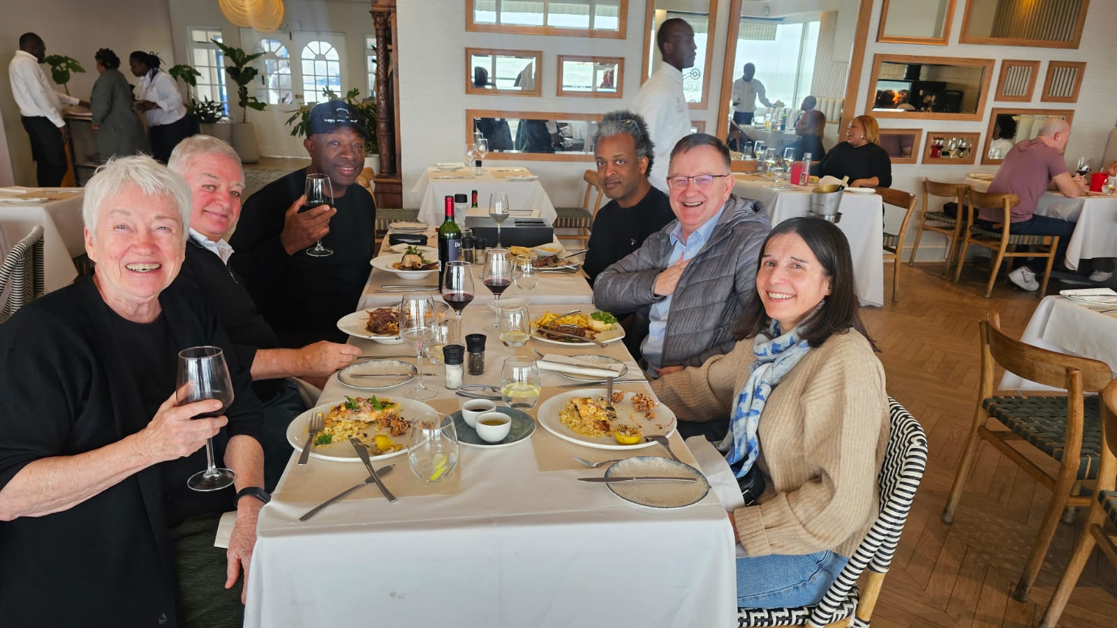 Friends raising a glass of Du Sol around the table