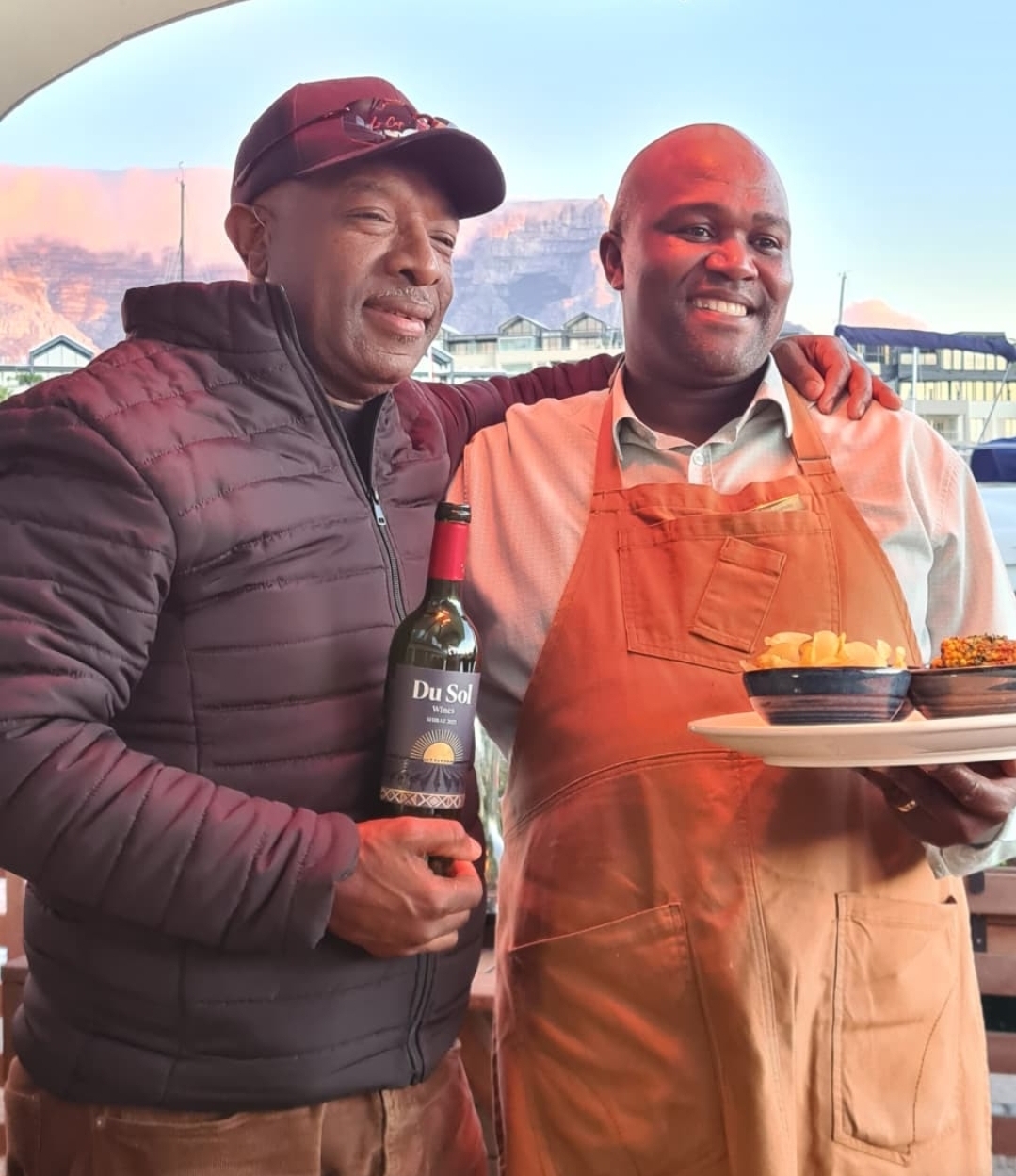 Du Sol Shiraz shared with a chef and a plate of food at the waterfront
