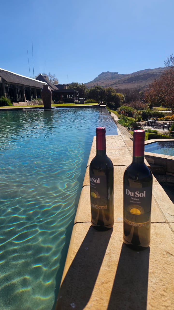 Du Sol reds beside a turquoise infinity pool with mountain views